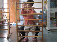 with the AFO, May learns walking using a ladder frame.
